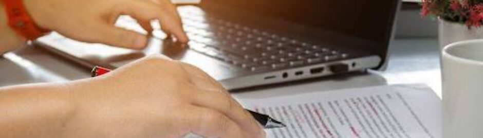 An image of a laptop and a person proofreading a stack of papers which represents knowing the disparities between editing and proofreading is crucial in grant writing. These stages may overlap, but they serve distinct purposes. Both are vital for refining, organizing, and submitting a polished final document. Understanding their nuances allows grant writers to improve proposal quality and boost success rates.