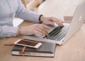 A woman sits at a desk, focused on her laptop screen. She is writing a grant proposal, fully committed to the philosophy that grant writing is more than just meeting funder requirements. In this image, she embodies the art of effectively narrating her organization's story, showcasing how their mission and vision align with the funder's objectives. With determination, she crafts a high-quality proposal that sets her apart from other applicants. Her dedication to detail and strategic storytelling is evident as she devotes herself to securing the necessary funding to bring her organization's goals to life.

